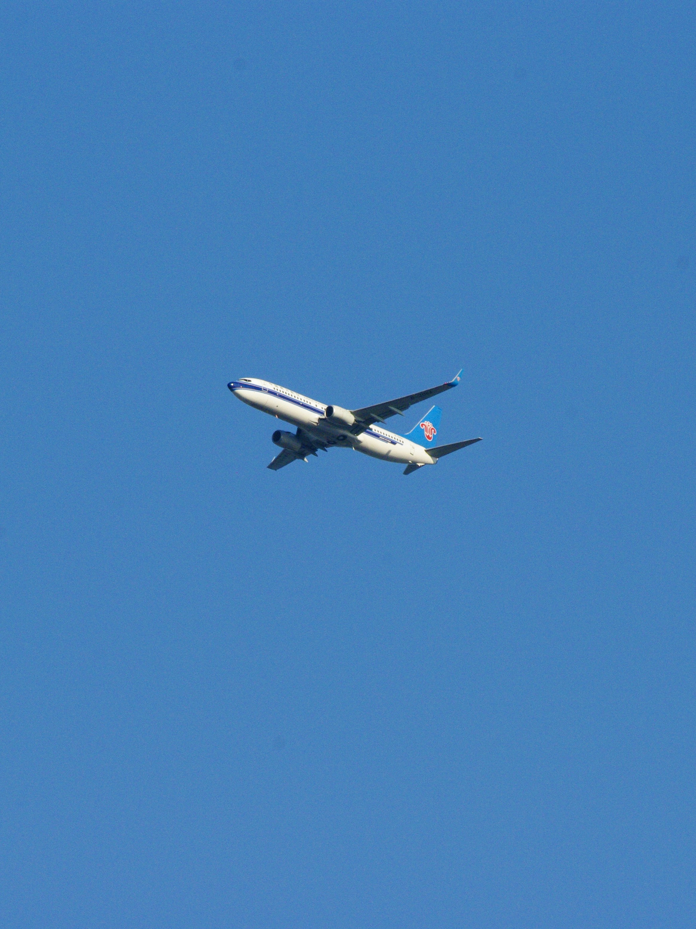 a large jetliner flying through a blue sky